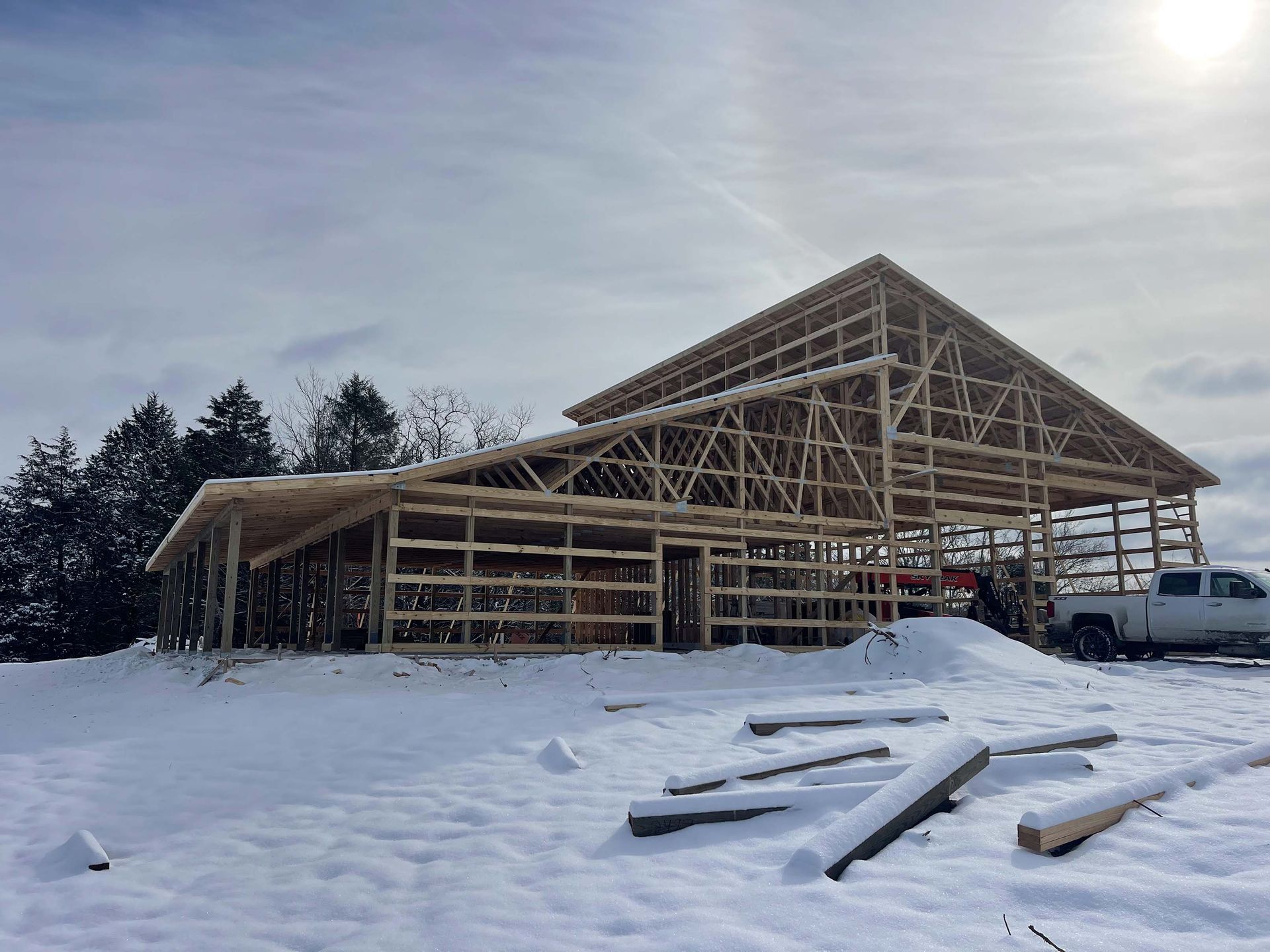 A large wooden structure is being built in the snow.