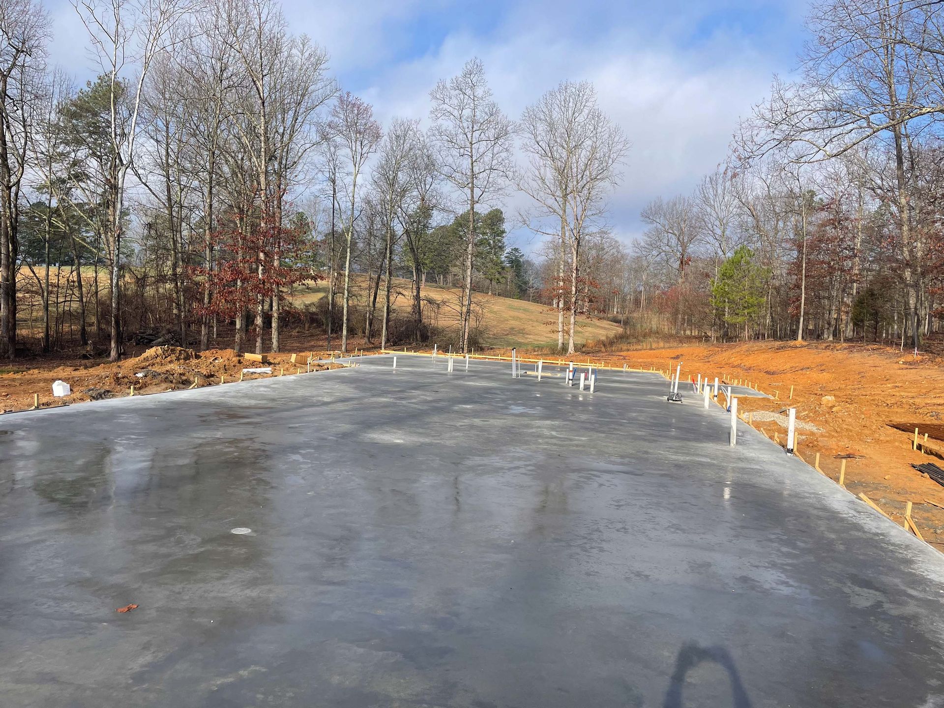 A concrete driveway with a lot of trees in the background.