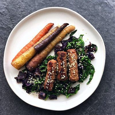 a white plate topped with carrots and sausages