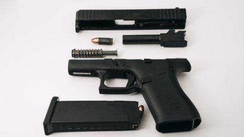 A disassembled gun is displayed on a table
