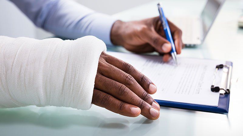 person in cast writing on clipboard