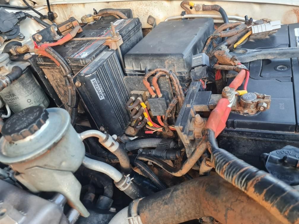 A close up of a car engine with a battery