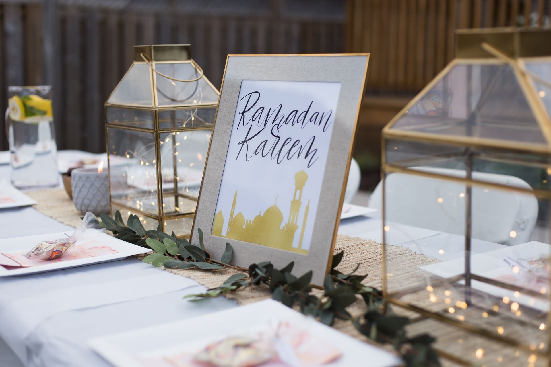 a table with plates, lanterns, and a sign that says 