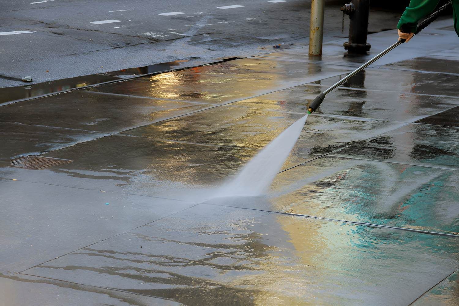 A Person Is Using A High Pressure Washer To Clean A Sidewalk — Out On A Limb Tree and Garden Care In Broulee, NSW