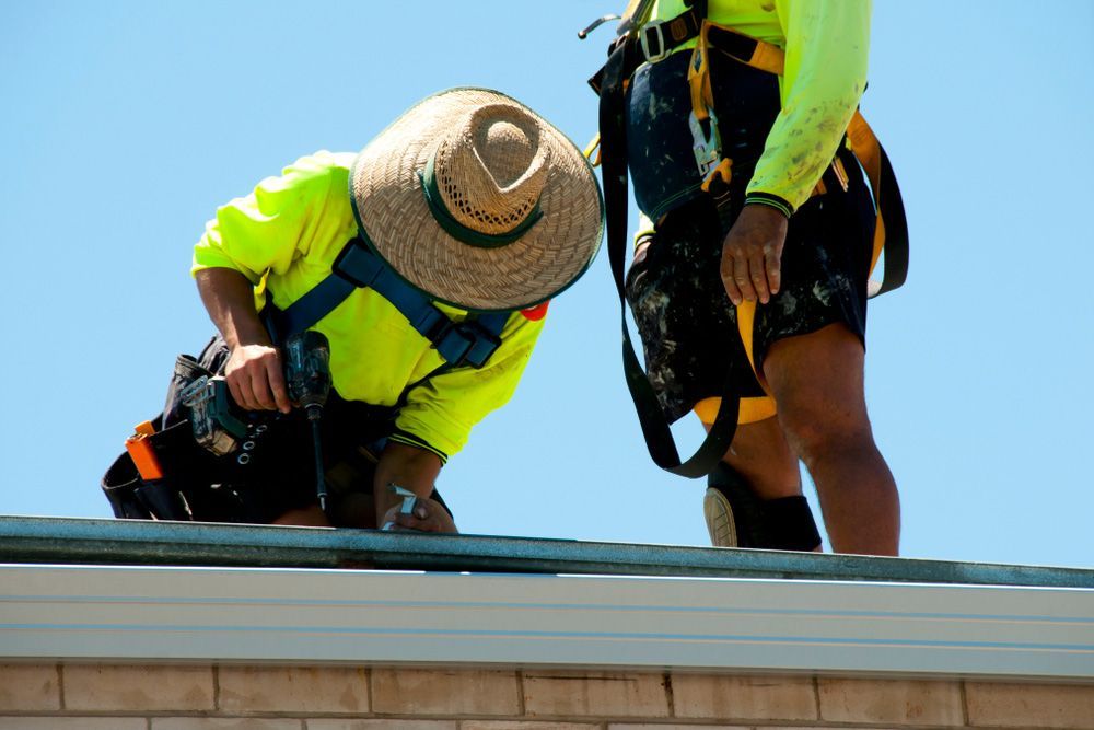 Two Men Installing a New Gutter System — ACT Roofing in Tuggeranong, ACT
