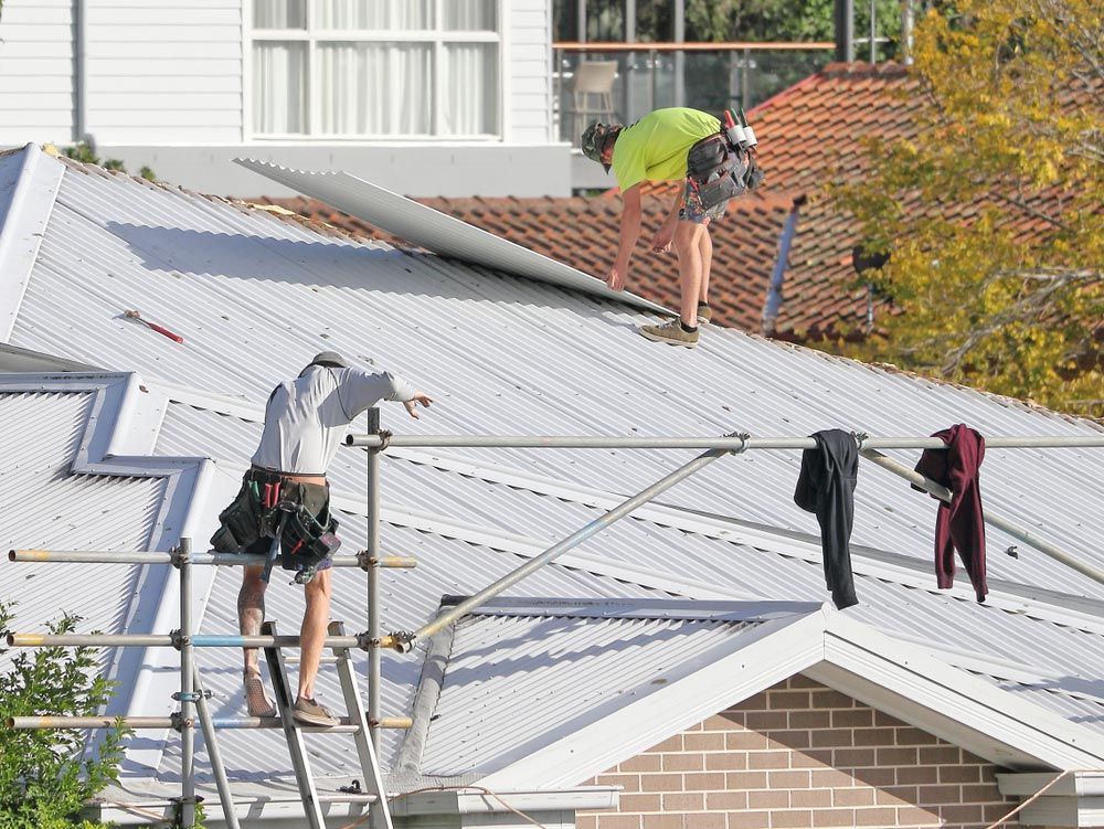 Two Men Are Working On A Roof for Restoration — ACT Roofing in Googong, NSW