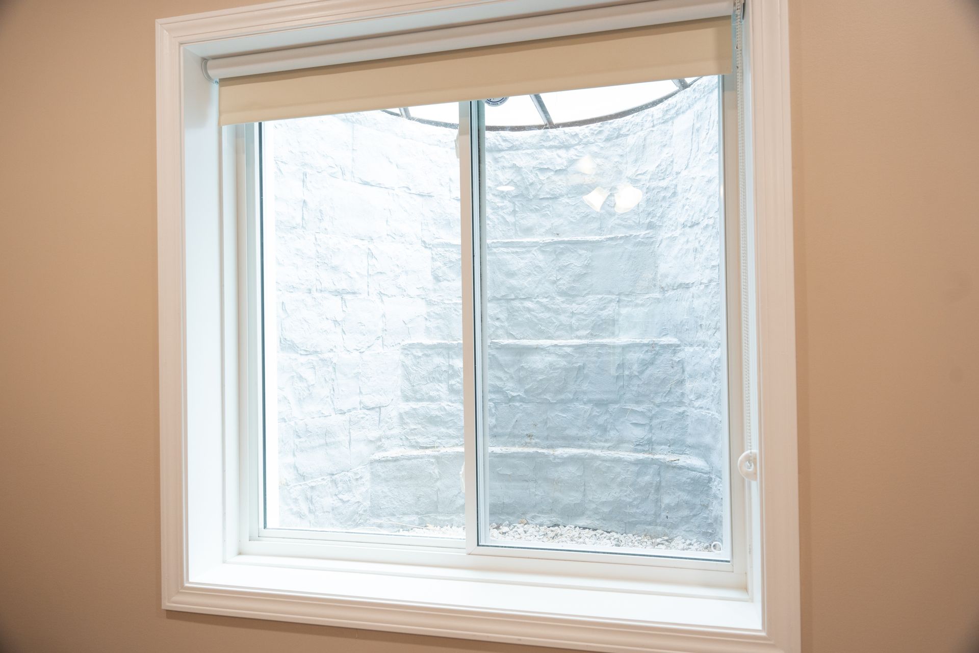 White double-pane window in a beige wall with frosted glass outside views