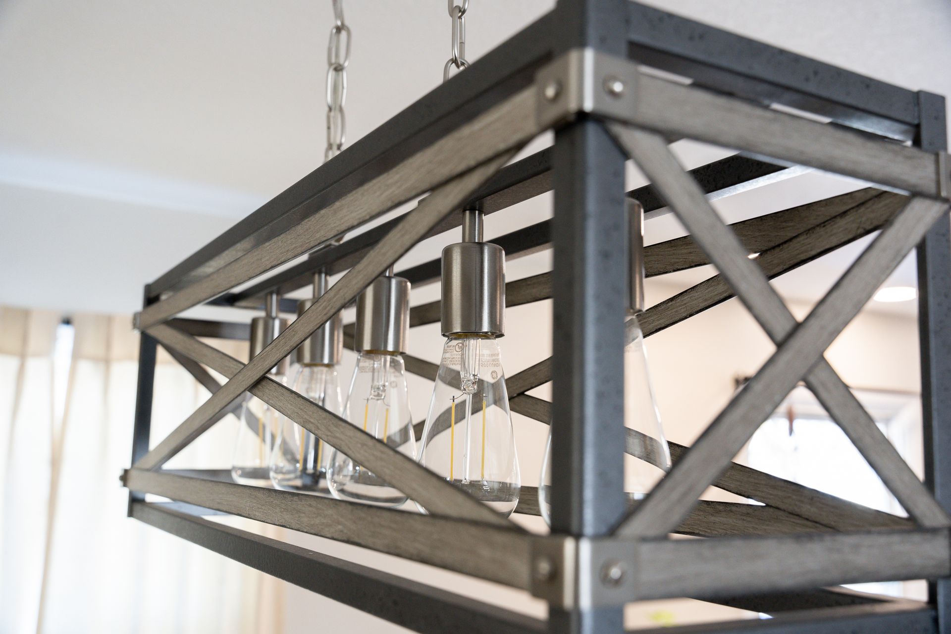Modern black metal pendant light with exposed bulbs hanging indoors