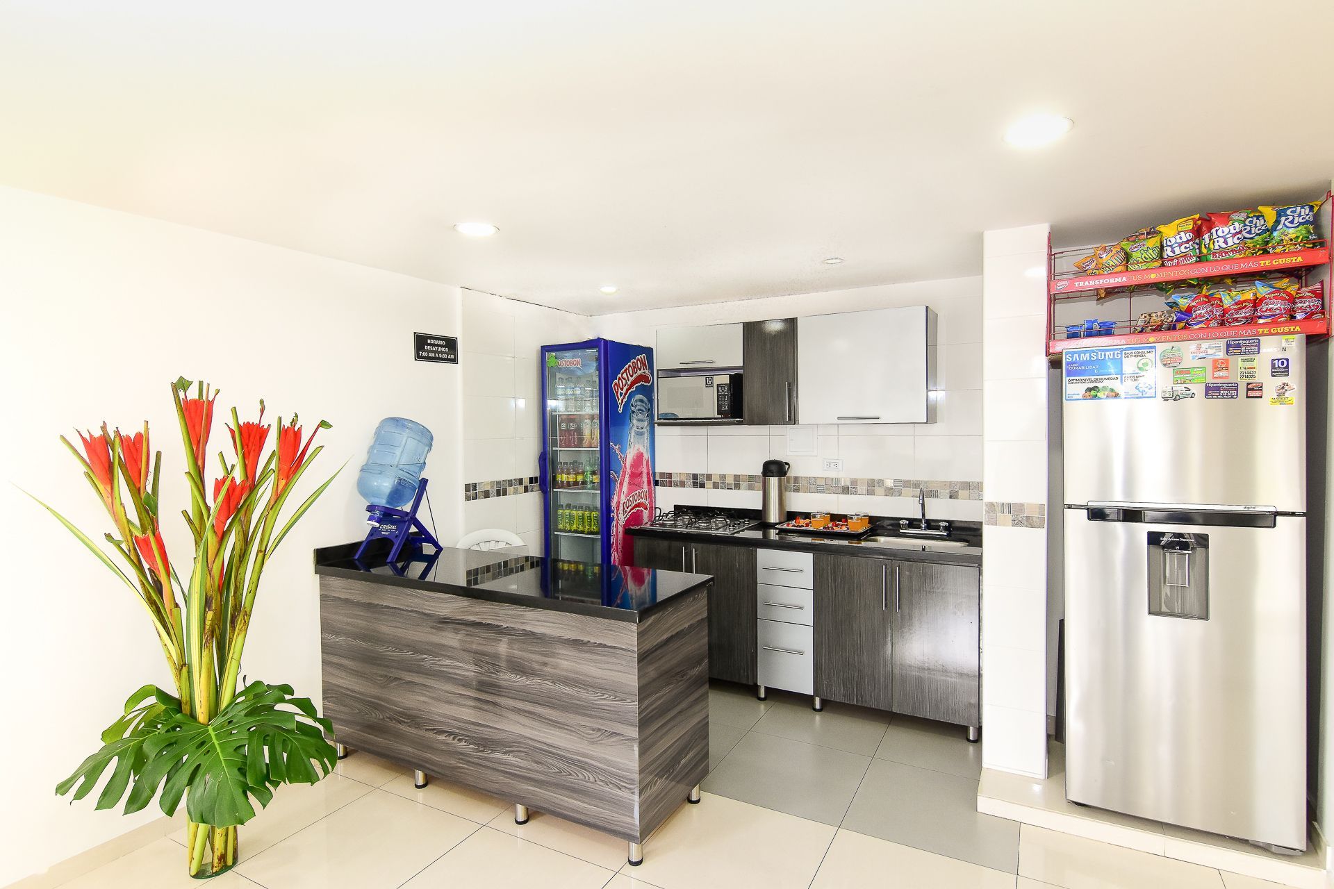 A kitchen with a stainless steel refrigerator and a water cooler.