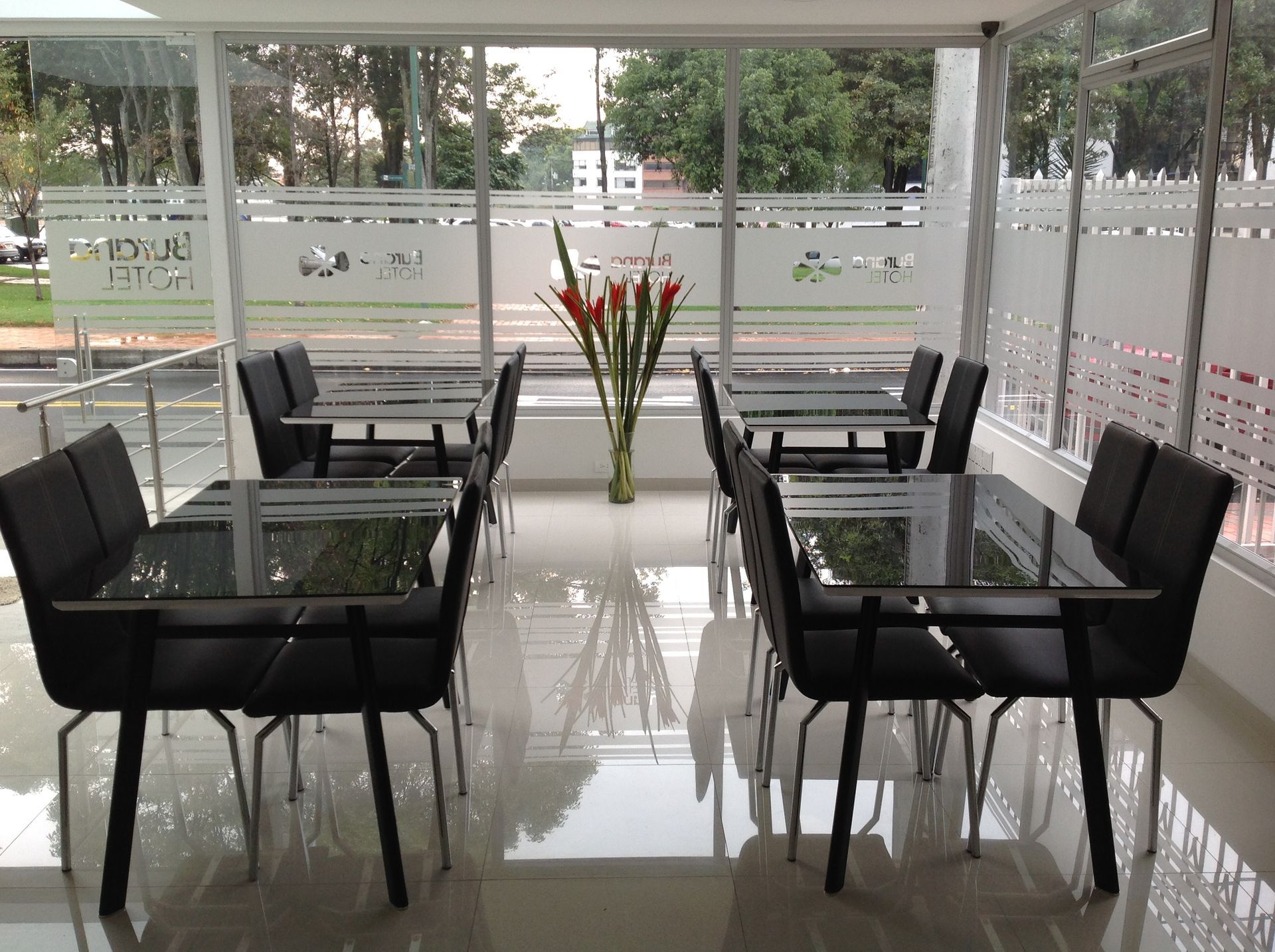 A dining room with tables and chairs and a vase of flowers