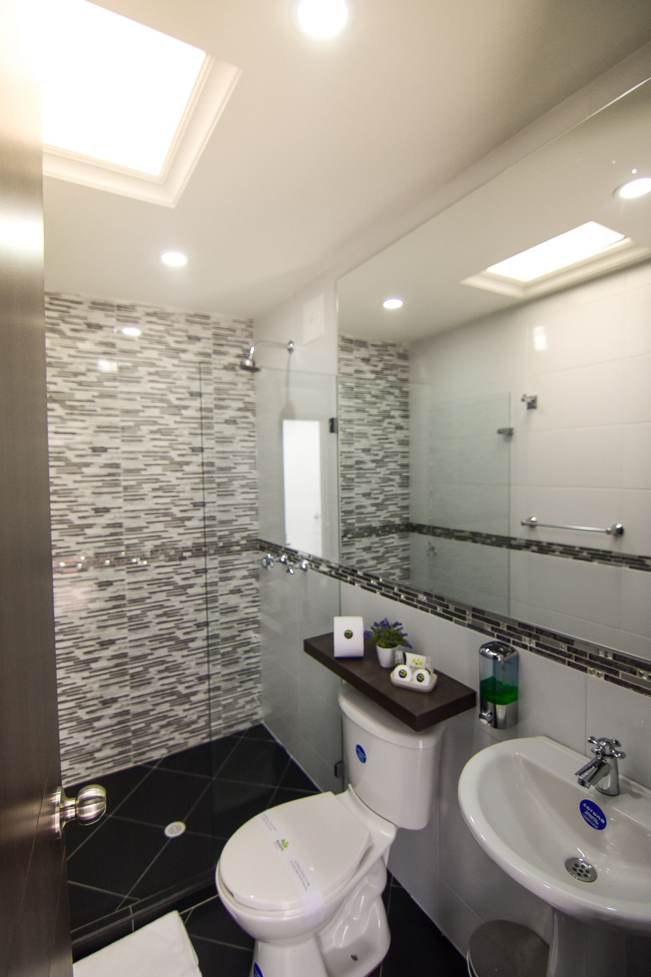 A bathroom with a toilet , sink and shower.