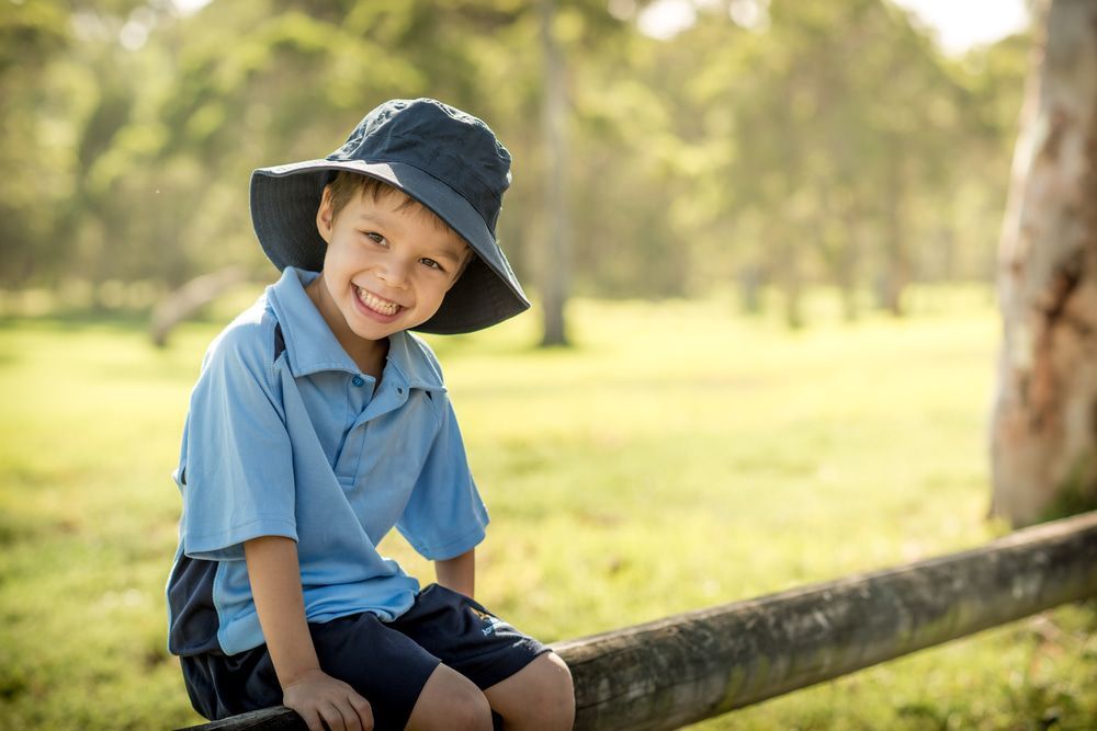 Smiling Child in a Blue Shirt and Hat — J & B Bus and Coach Pty Ltd In South Murwillumbah, NSW