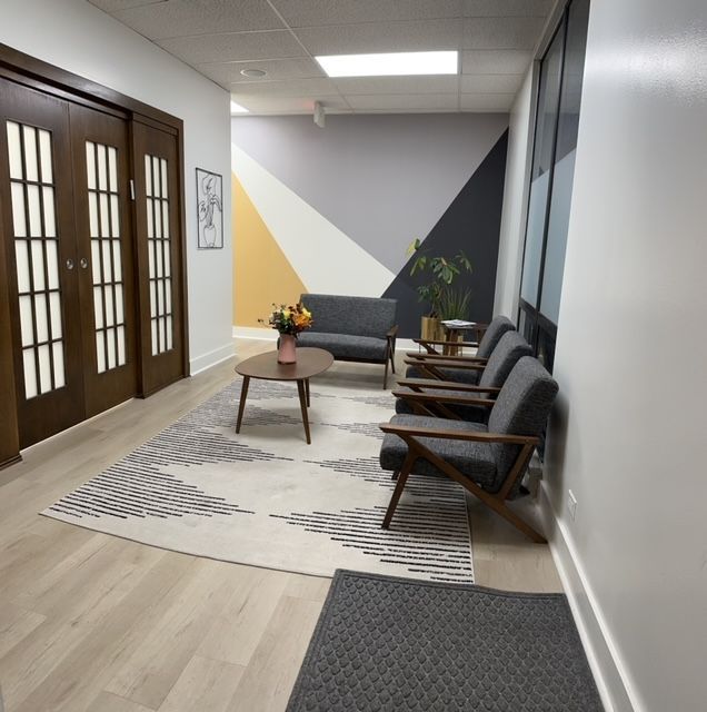 A waiting room with a couch and chairs and a coffee table at orion tms therapy