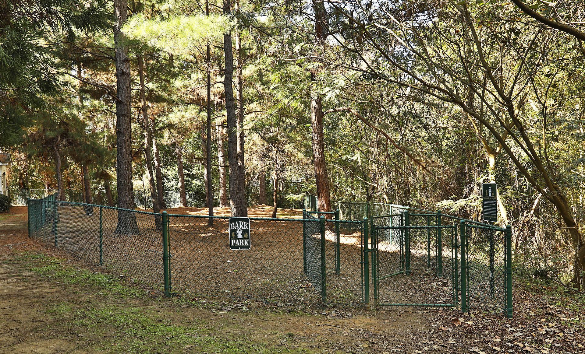 a dog park with a green fence and trees at Thornblade, South Carolina, 29615