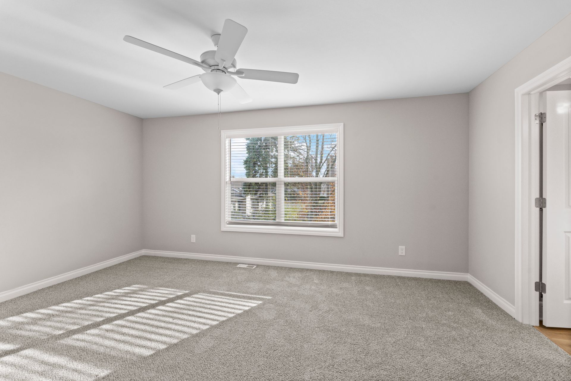 Photo of a large bedroom showing a ceiling fan