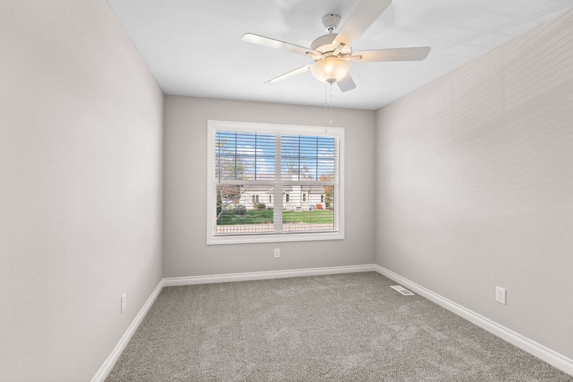 Photo of a small bedroom with a ceiling fan and a wide window