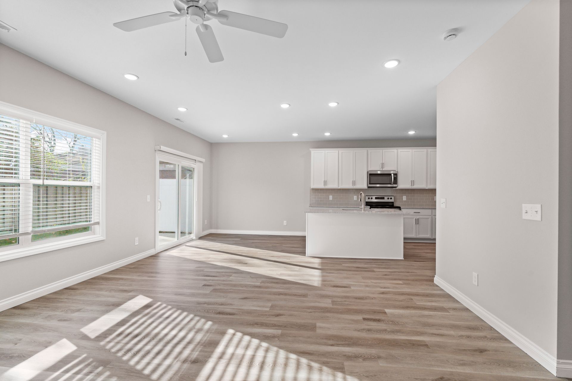 Photo of a large open space living room with the kitchen in the background
