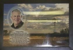 Framed landscape print with a smiling portrait on the left and a block of text in the lower left.