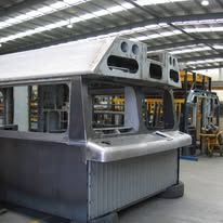 Gray industrial booth or kiosk under construction inside a factory warehouse