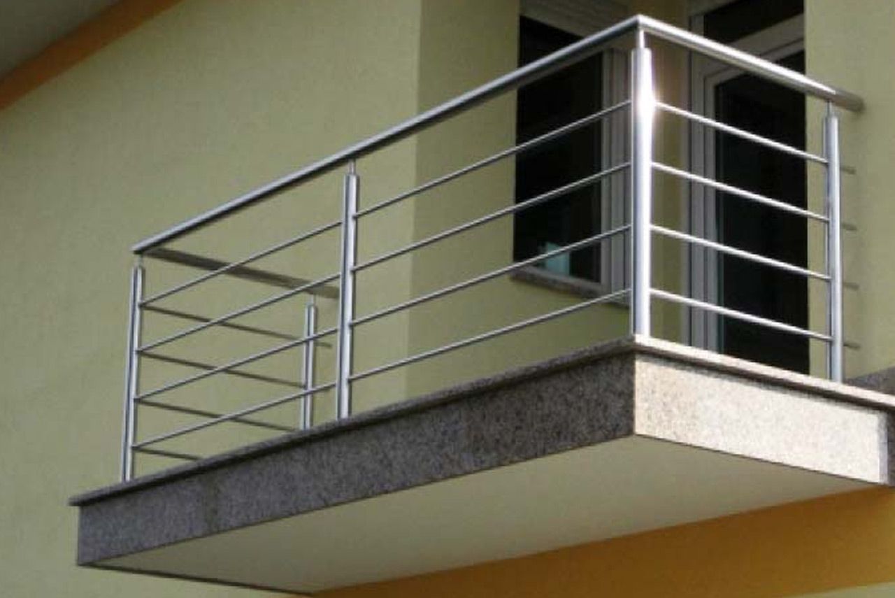 Modern balcony with metal railing on a beige building