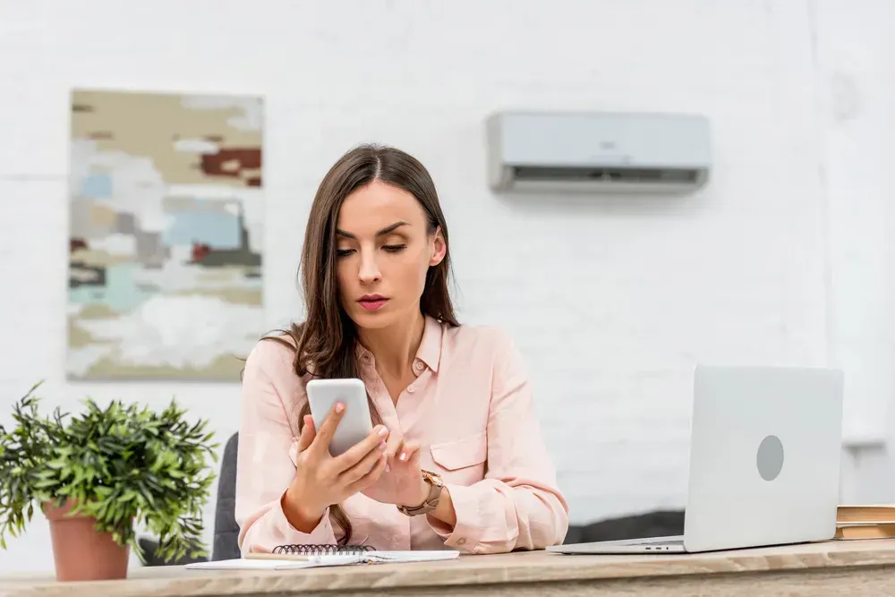 Employee using a personal phone for work at a desk