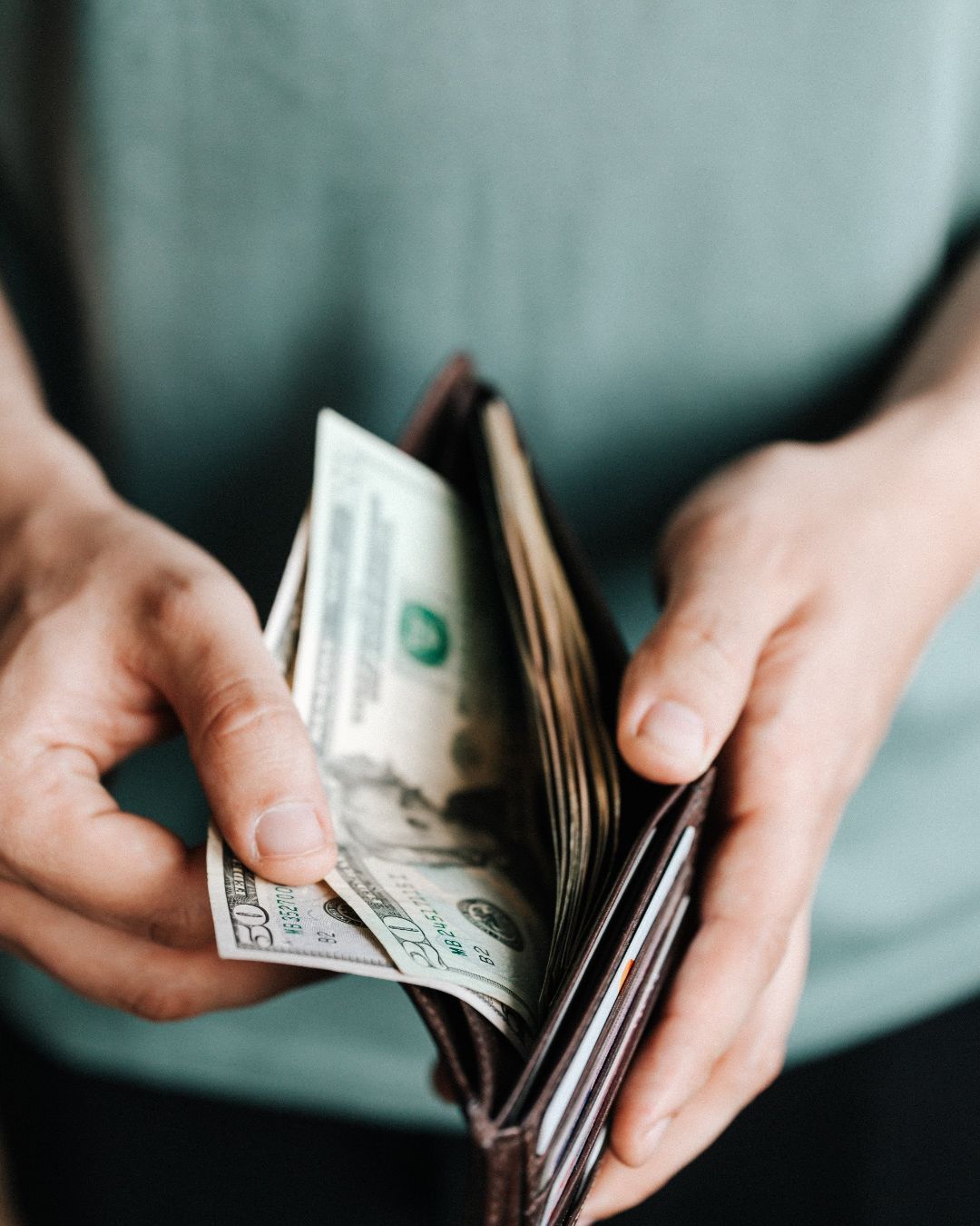 A person is taking money out of their wallet