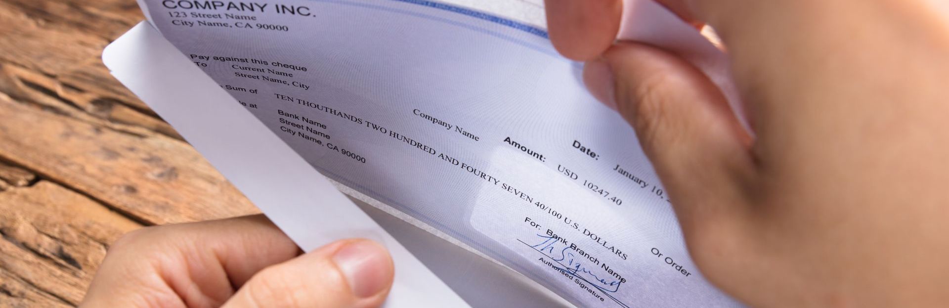 A person is holding a paycheck their hand.