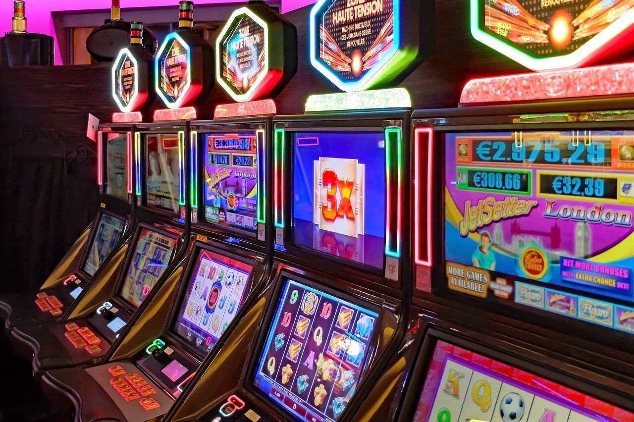 Row of colorful slot machines in a neon-lit casino