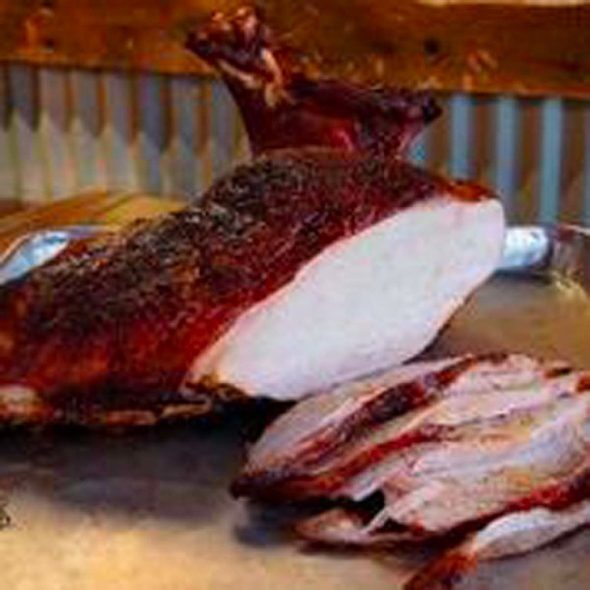 Roasted pork shoulder with crispy crackling and sliced meat on a tray