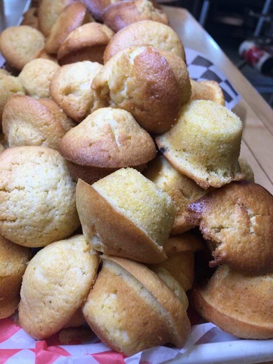 Tray of golden-brown baked muffins or madeleines piled together
