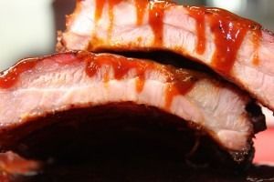 Close-up of sliced glazed roasted meat with a glossy brown sauce