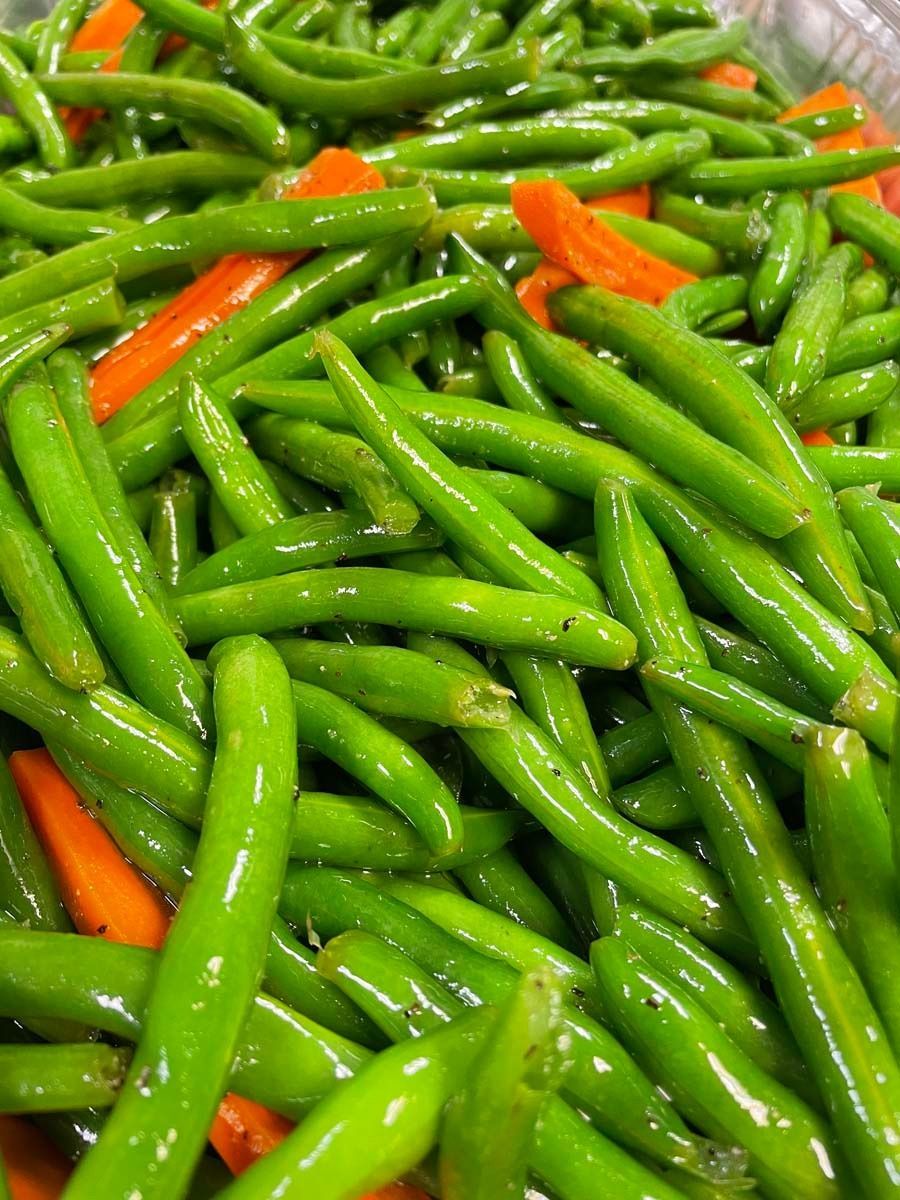 Close-up of green chili peppers with a few orange-red peppers mixed in