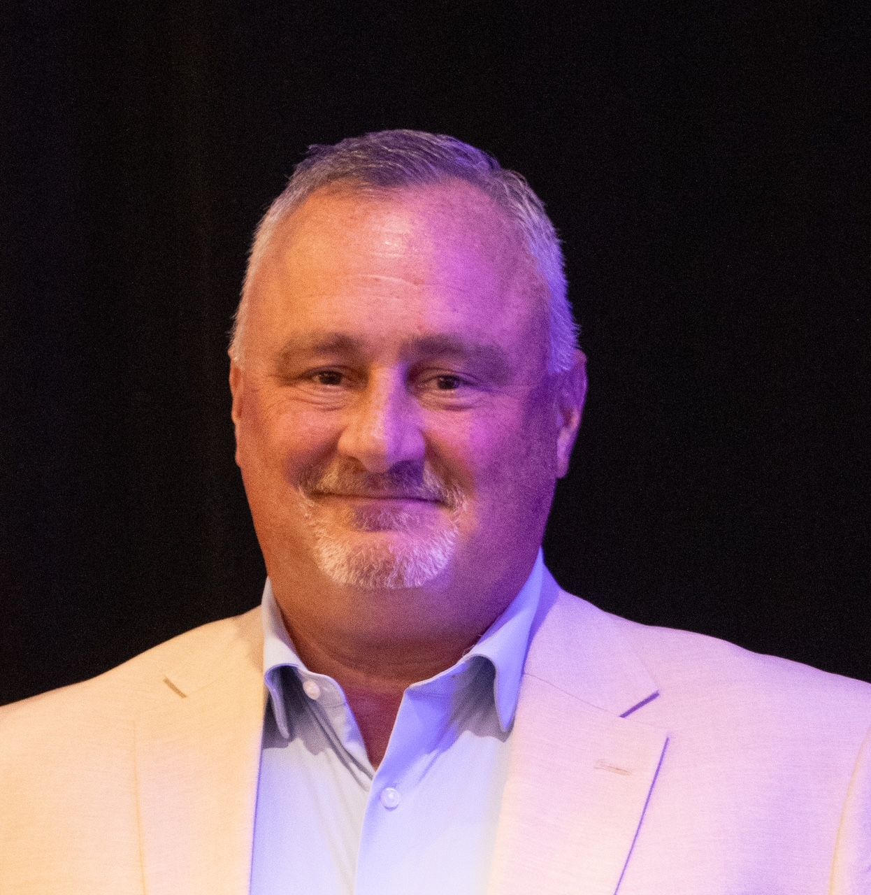 Sheriff in tan uniform standing before U.S. and Tennessee flags