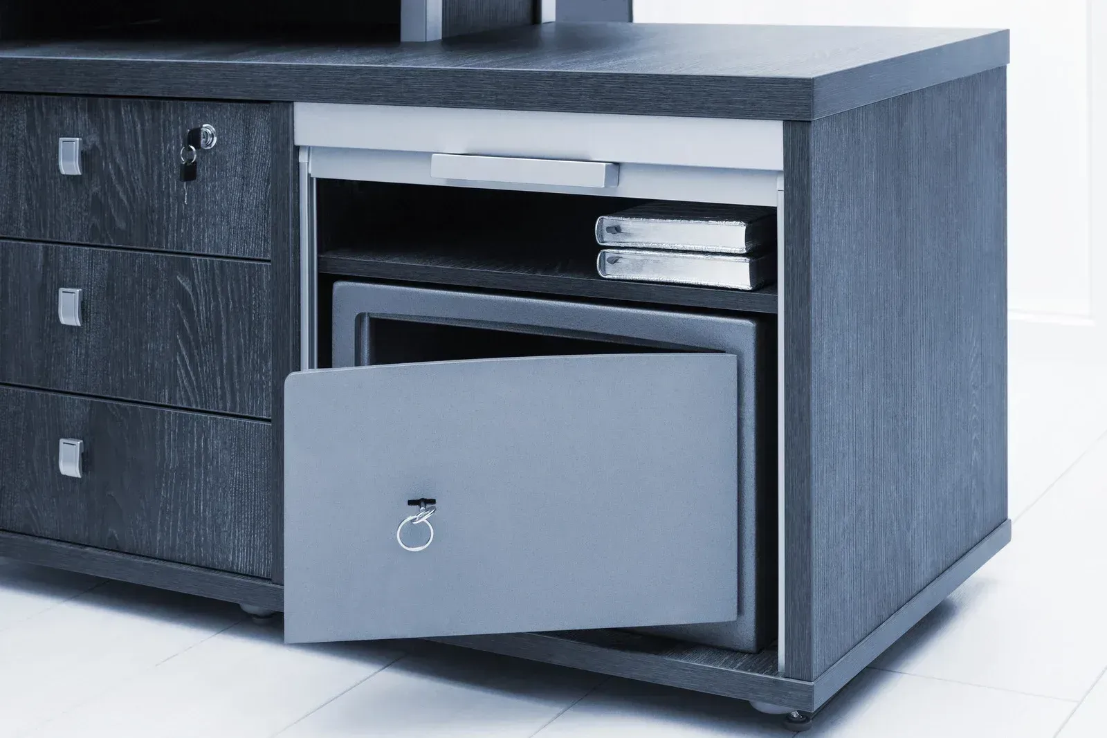 Open drawer in a dark wooden desk revealing files inside