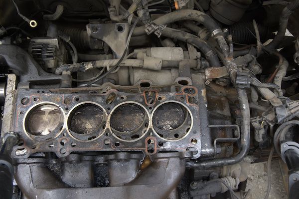 Engine block with the cylinder head removed, revealing the cylinders and pistons. | Dave's Automotive LLC