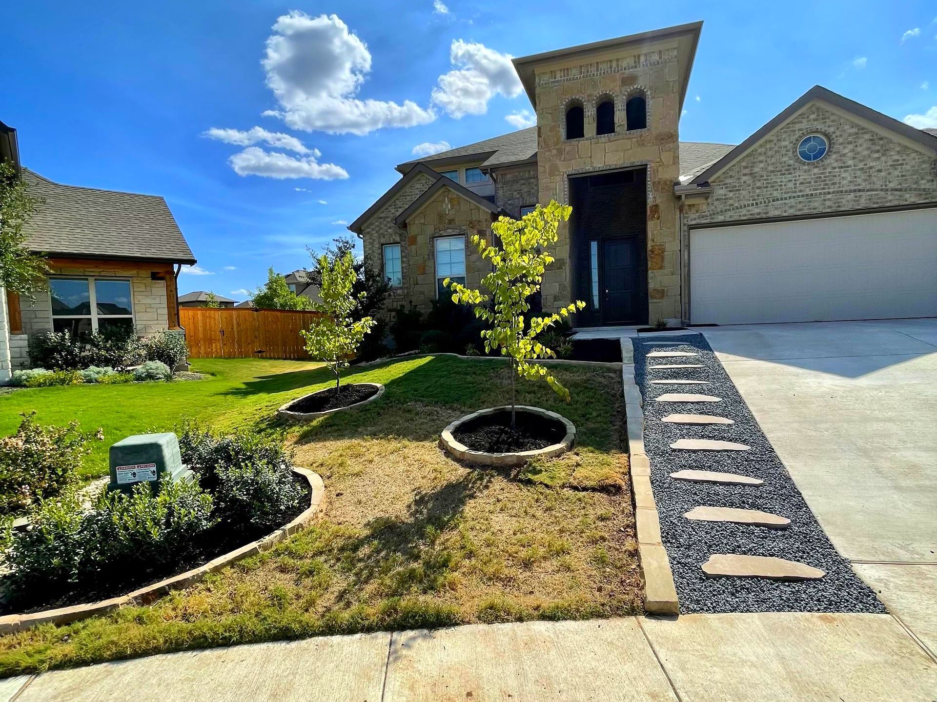House exterior with stone facade, landscaping, and pathway of stepping stones.