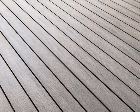 Diagonal gray wooden deck boards with thin dark gaps and a textured finish