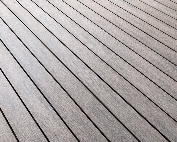 Diagonal gray wooden deck boards with thin dark gaps and a textured finish