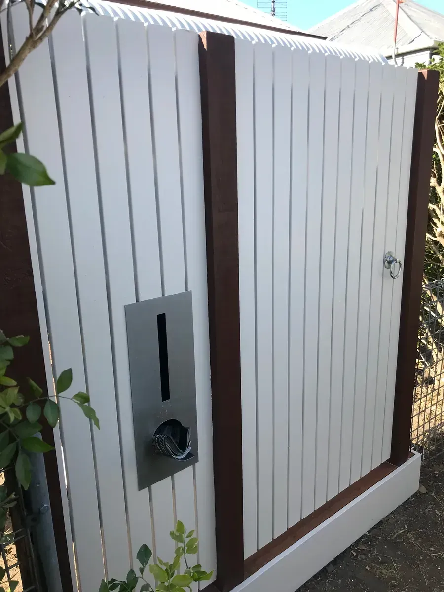 White outdoor utility cabinet with brown trim and a small gray meter box on the front panel.