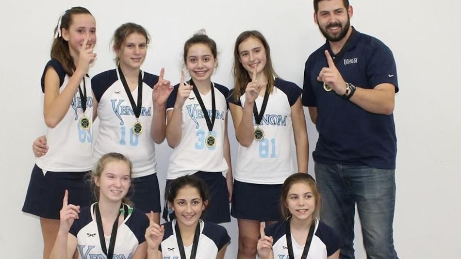 A group of young girls are posing for a picture with medals around their necks
