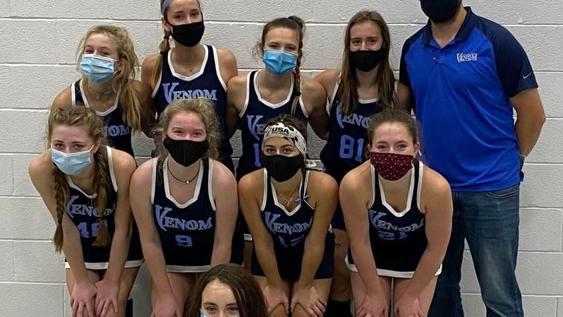 A group of people wearing masks are posing for a picture.