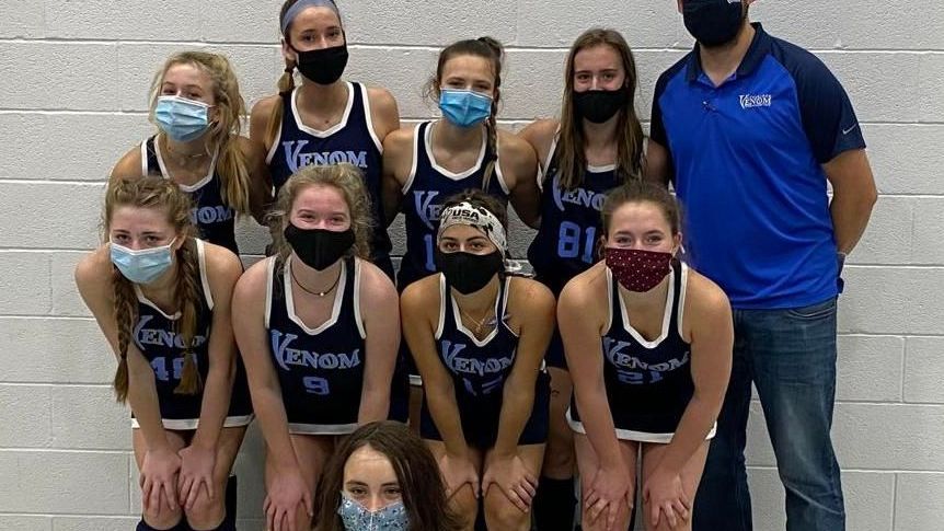 A group of female athletes wearing masks are posing for a picture.