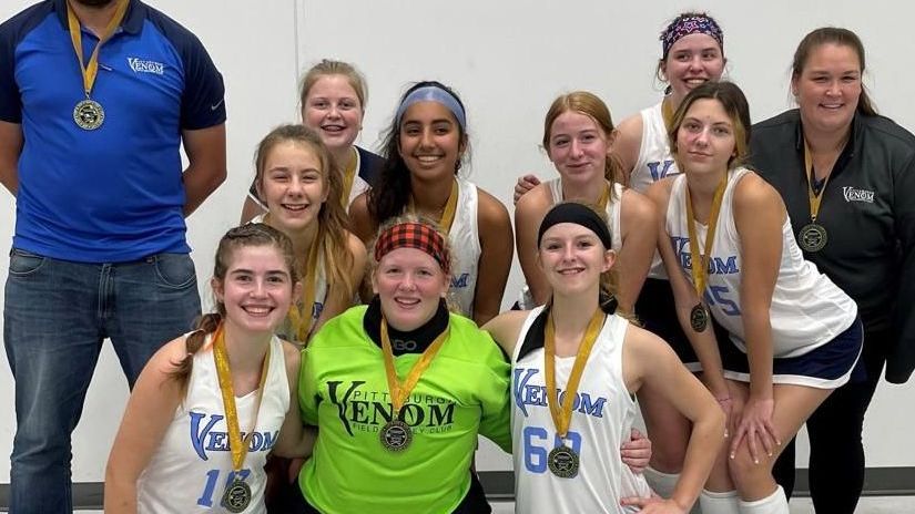A group of female athletes posing for a picture with medals around their necks.