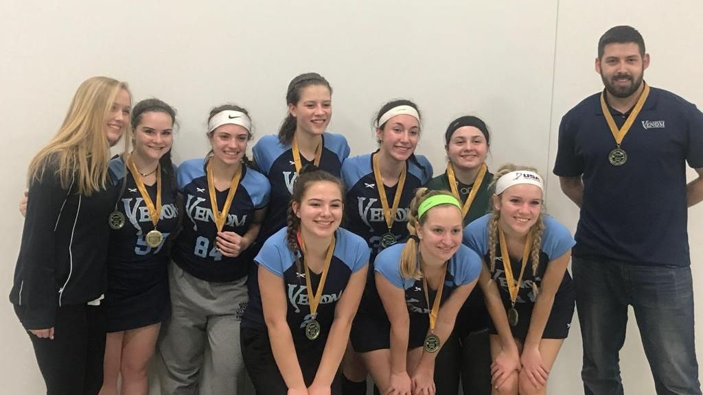 A group of young girls are posing for a picture with medals around their necks.