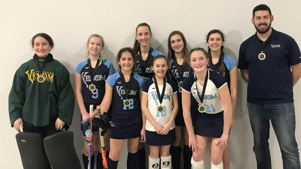 A group of young girls are posing for a picture with their coaches.