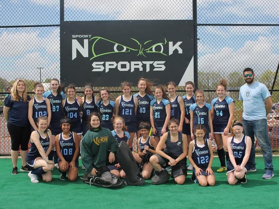 A group of people posing for a picture in front of a sign that says nc kayak sports