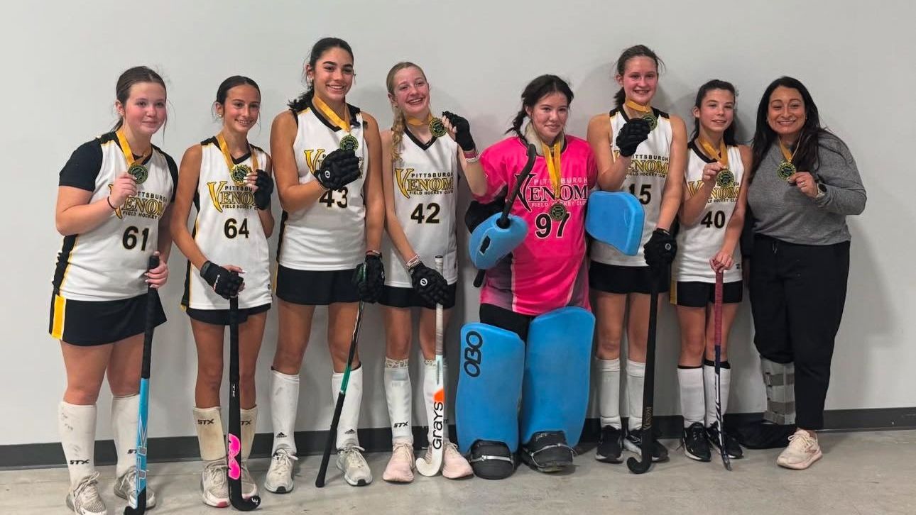 A group of young girls are posing for a picture with medals around their necks.