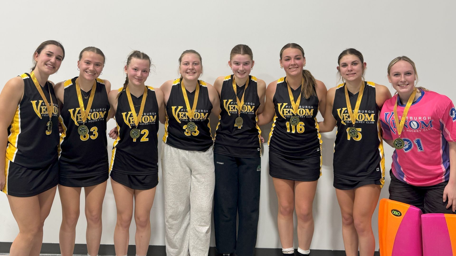 A group of young women wearing medals are posing for a picture.