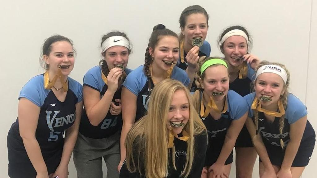A group of young girls are posing for a picture with medals around their necks.