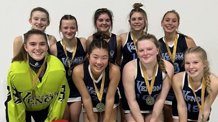 A group of young girls are posing for a picture with medals around their necks.
